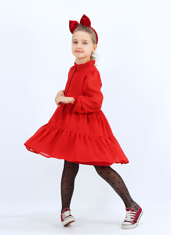 Ефирна рокля от шифон е със свободен силует разкроена в долната част на волани. В горната част роклята е тип риза с копчета и къдри на яката. Моделът е с дълги ръкави, които завършват с фин ластик, който образува къдри. Роклята е с памучна подплата по цялата дължина в червен цвят, Момичета 4 - 12 години, Zinc